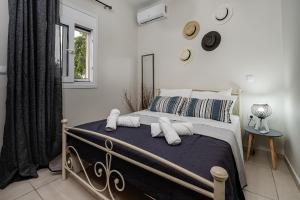 una camera da letto con letto, cuscini e finestra di Aria Apartment a Città di Zante