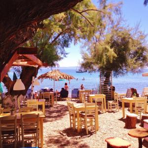 un gruppo di tavoli e sedie su una spiaggia di Petalidi a Skala Mistegnon