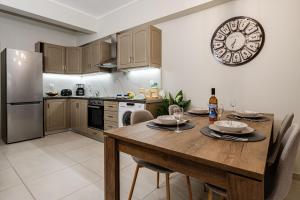 a kitchen with a wooden table and a clock on the wall at Aria Apartment in Zakynthos