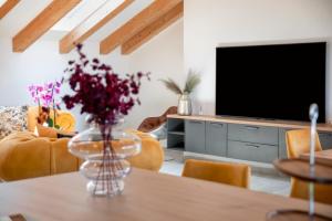 a living room with a vase of flowers on a table at Boutique Residence Arion in Rovinj
