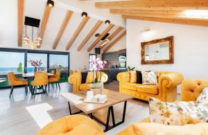 a living room with yellow furniture and a table at Boutique Residence Arion in Rovinj