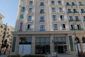 un grande edificio bianco con un orologio sopra di Apart Hotel Istaravshan a Tashkent