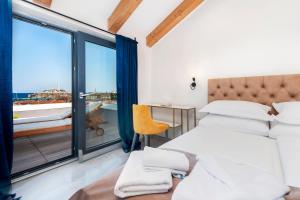 a bedroom with two beds and a balcony at Boutique Residence Arion in Rovinj