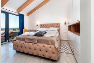 a bedroom with a large bed and a large window at Boutique Residence Arion in Rovinj