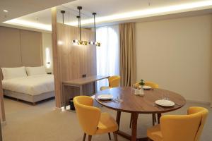 タシュケントにあるApart Hotel Istaravshanのテーブル、椅子、ベッドが備わる客室です。