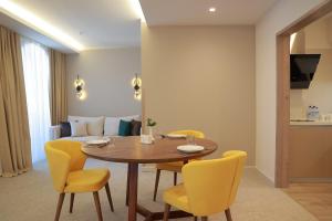 塔什干Apart Hotel Istaravshan的一间带桌子和黄色椅子的用餐室