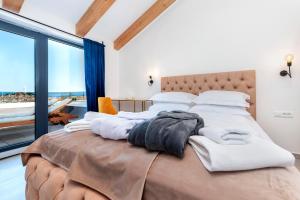 a bedroom with a large bed with white sheets at Boutique Residence Arion in Rovinj