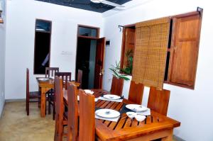 a dining room with a wooden table and chairs at Super King Star Holiday Resort in Anuradhapura