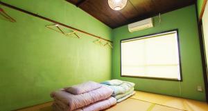a green room with a bean bag bed and a window at ゲストハウス 編湊 in Nakaminato +4 photos