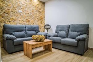 Sala de estar con 2 sofás y mesa de centro en HOTEL RURAL LA TEJA, en Segura de León