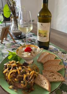 a plate of food with a bottle of wine and bread at Weingut und Gästezimmer Jörg Thul in Detzem