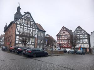a group of buildings with cars parked on a street at Ferienwohnung in Treysa in Schwalmstadt
