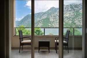 a room with two chairs and a table in front of a window at Apartmani na Plaži in Risan