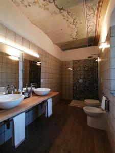 La salle de bains est pourvue de 2 lavabos et de 2 toilettes. dans l'établissement Le Cornici - Cascina di Charme, à Diano dʼAlba