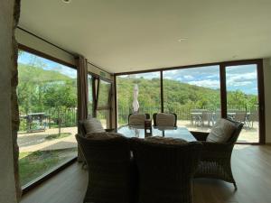 ein Esszimmer mit einem Tisch und Stühlen sowie einem großen Fenster in der Unterkunft Las Terrazas de Chilla in Candeleda