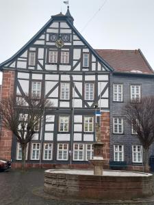 a black and white building with a fountain in front of it at Ferienwohnung in Treysa in Schwalmstadt