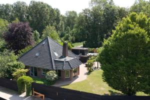 eine Luftansicht eines Hauses mit Dach in der Unterkunft Family Villa in Forest with shared pool & Wellness in Zeewolde