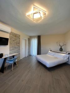 una camera d'albergo con letto, scrivania e letto Sidx Sidx. di Le Cornici - Cascina di Charme a Diano dʼAlba