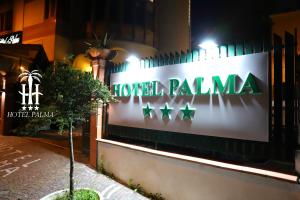 una señal de palma del hotel en el lateral de un edificio en Hotel Palma en Castellammare di Stabia