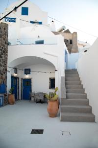un escalier menant à un bâtiment blanc avec des portes bleues dans l'établissement Amphora Villas Santorini Akrotiri, à Akrotiri