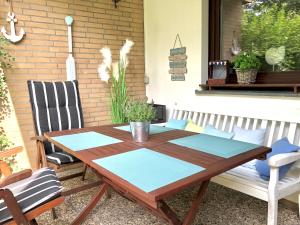 einen Holztisch und Stühle auf einer Terrasse in der Unterkunft MEI71 Ferienwohnung Strandlust F in Niendorf