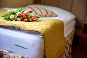 a bouquet of flowers sitting on top of two beds at Hotel pod Wierzba in Świdnica