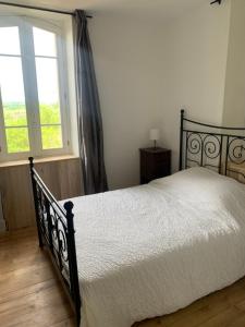 a bedroom with a bed and a window at La Forge de Béduer in Béduer