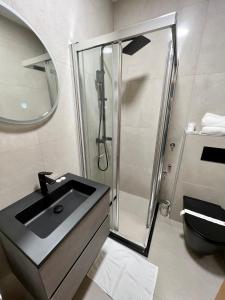 a bathroom with a glass shower and a sink at Hotel Brkic in Sarajevo