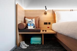 a hotel room with a bed and a table with a drink at Moxy Manchester City Centre in Manchester