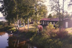 een huis met een vijver ervoor bij Hindås Lake Camp in Hindås