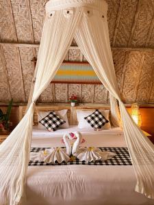 a bedroom with a bed with a mosquito net at Penida Hills in Nusa Penida