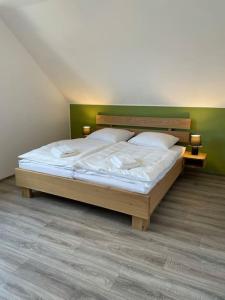 1 dormitorio con 1 cama con sábanas y almohadas blancas en Tolles Gästehaus an der Wurzel, en Hürtgenwald