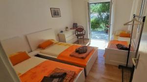a bedroom with two beds and a door to a patio at Apartman Bonkovic in Gdinj