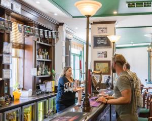 a woman standing at a bar in a pub at The Beaconsfield Hotel in Fremantle