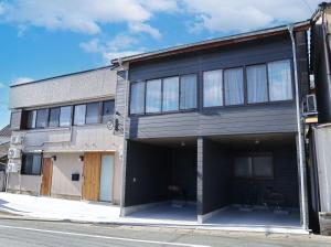 a building with a garage on a street at さきみや in Goto