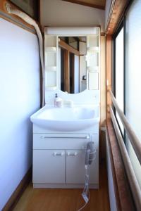 a bathroom with a sink and a mirror at さきみや in Goto