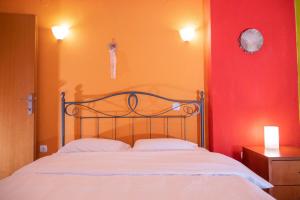 a bed in a room with a red and orange wall at Natural Oasis Villa in Nea Fokea
