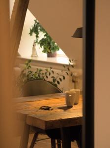 Akaciegaarden Bed & Breakfast في Hårlev: طاولة خشبية فوقها كوب