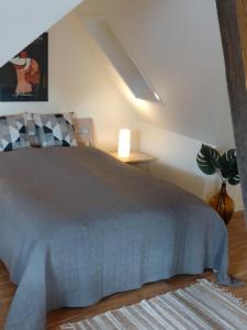 een slaapkamer met een bed en een lamp en een plant bij Akaciegaarden Bed & Breakfast in Hårlev