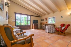 a living room with chairs and a table and a tv at Can Cama Rotja in Inca