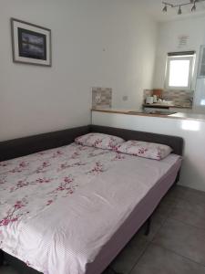 ein Schlafzimmer mit einem großen Bett mit rosa Blumen drauf in der Unterkunft Paphos Studios in Paphos City