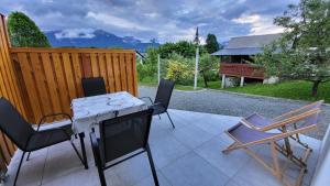 un patio con mesa, sillas y una valla en Annie's apartment en Bled