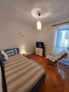 een slaapkamer met een bed, een tv en een raam bij Apartment Anna Vis in Vis