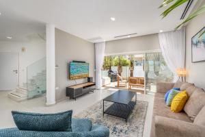 un soggiorno con divano e TV di Boutique Villa with Rooftop Pool a Netanya