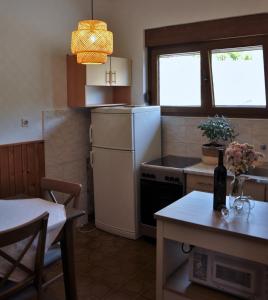 a small kitchen with a white refrigerator and a table at Jungle & Sea Boxavia in Božava