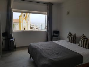 um quarto com uma cama e uma janela com uma igreja em Apartamento Cristino em Luz