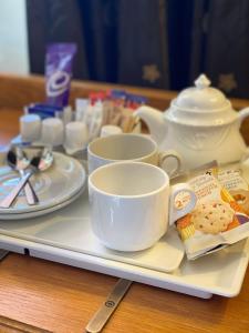 a tray with cups and saucers on a table at The Dutch Mill Hotel in Aberdeen