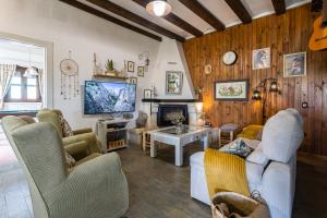a living room with couches and a tv at Finca el Albero in Carratraca
