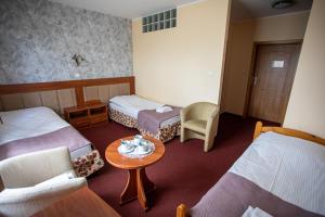 una camera d'albergo con due letti e un tavolo di Hotel pod Wierzba a Świdnica