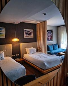 a bedroom with two beds and a mirror at Aurora Resort & Spa in Berovo